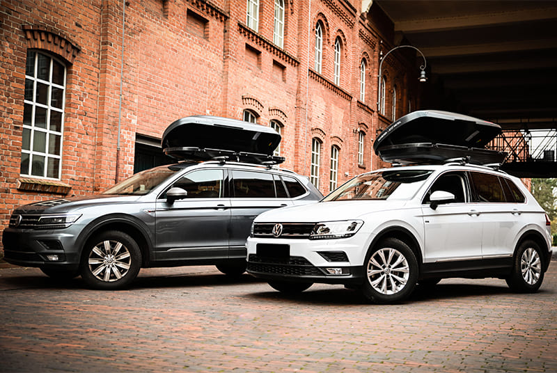 Zwei Autos mit Dachboxen in unterschiedlicher Groesse Zwei Autos mit Dachboxen in unterschiedlicher Groesse